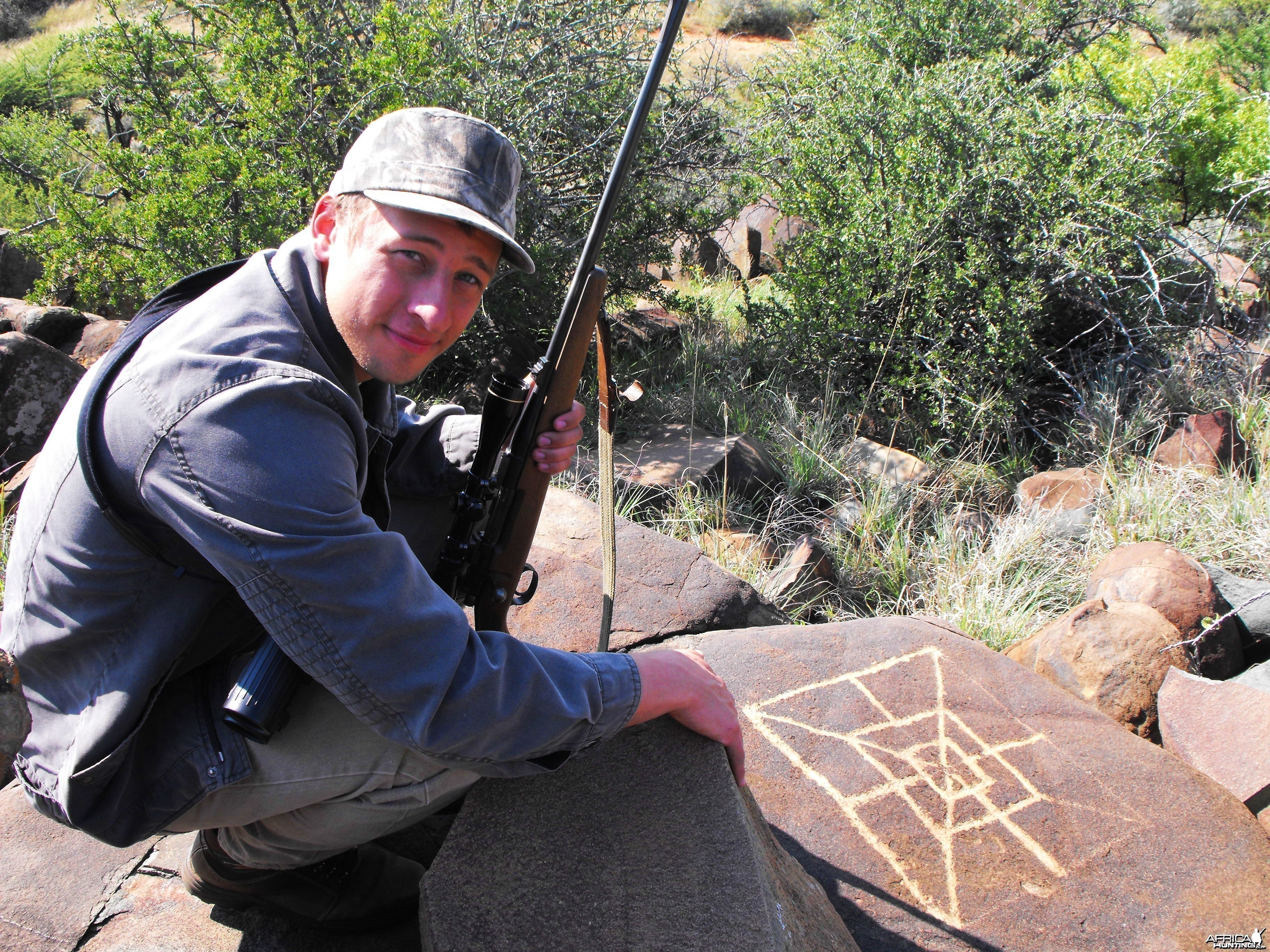 Brother next to very old local rock drawing game board!