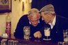 Two old men in discussion at bar having a beer.jpg